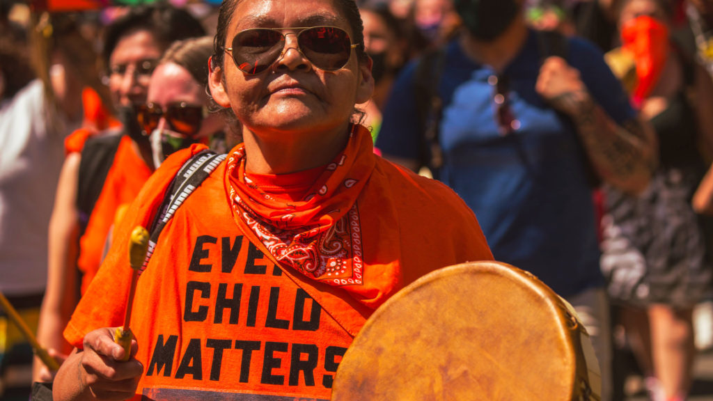 A photo of a person wearing an orange shirt that reads, "Every Child Matters."