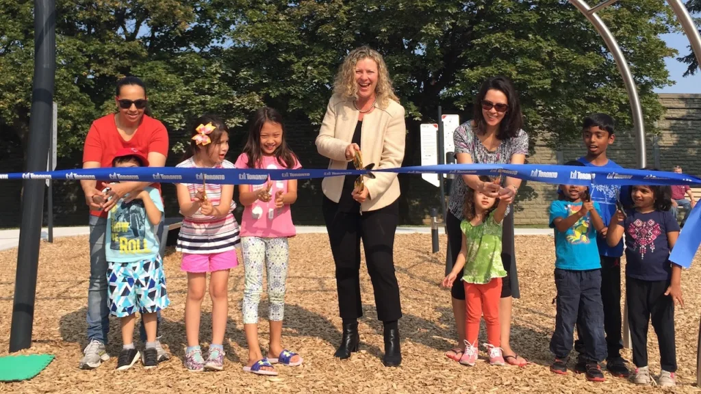 jaye Robinson cutting the ribbon with kidsa at a new playground